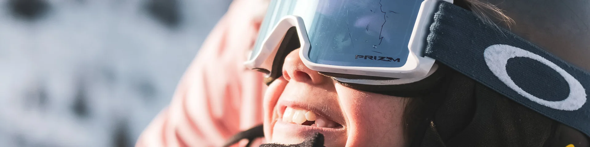 Une mère et son fils sont sur un télésiège pour monter en haut de la piste de ski. Ils sont tous deux très complices et semblent être impatients de skier, au vu de leur grand sourire et expression du visage, contemplant les pistes de ski.