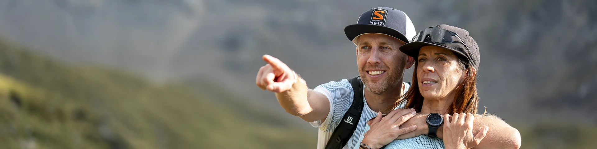 Couple faisant une randonnée sportive au lac de Tardevant. Ils sont très complices et l'homme point quelque chose du doigt avec émerveillement. Ils sont habillés en tenue de randonnée bleu clair, blanc et noir.