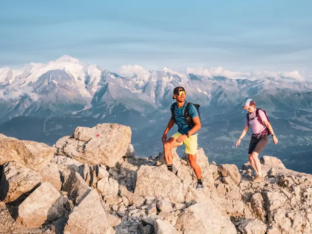 Un couple de randonneurs font l'ascension de la pointe Percée en été