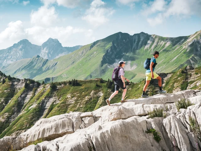 Couple de randonneurs gravissant le pointe Percée en été avec une nature verdoyante