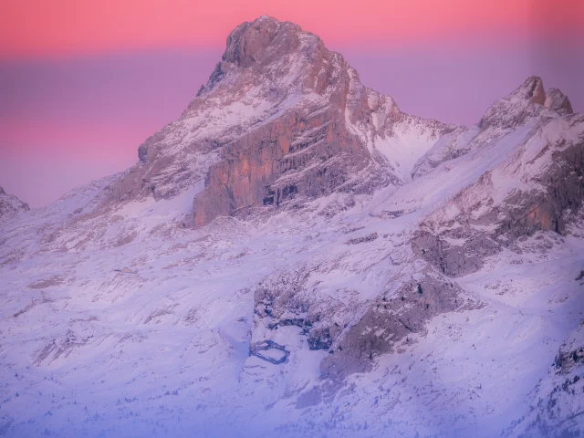 photo de la pointe percée dans le massif des aravis au coucher de soleil, le ciel a des couleurs éclatantes qui vont du orange au violet