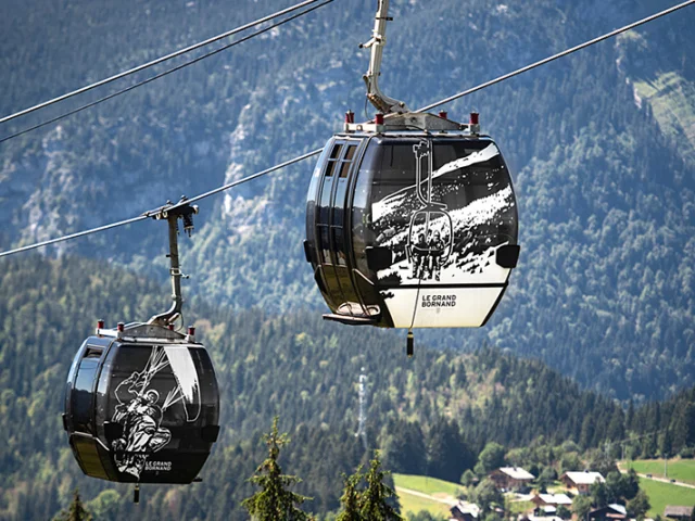 Vue des télécabines du Rosay au Grand-Bornand, décorées avec des illustrations artistiques en noir et blanc.