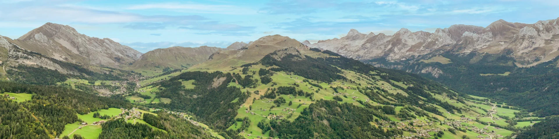 Vue aérienne en été du Grand-Bornand avec le Village, le Chinaillon, la vallée du Bouchet, le Jalouvre, la Chaîne des Aravis et la pointe Percée...