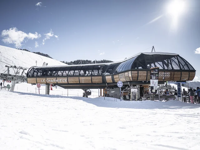 Inauguration du nouveau télésiège débrayable 6 places du Charmieux en 2020. Nous pouvons voir le nouveau télésiège, sur le front de neige, dans un décor enneigé.