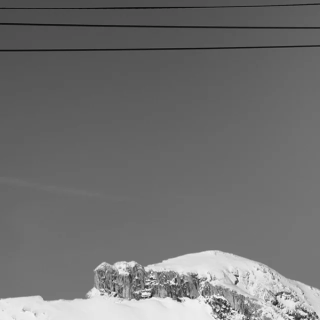 Two suspended Grandborama cabins, decorated with works of art, with the snow-capped peaks of Grand-Bornand in the background.