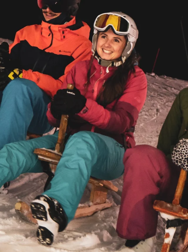 3 personnes habillés chaudement sont assises chacun sur un paret avec le sourire, la photo est prise de nuit