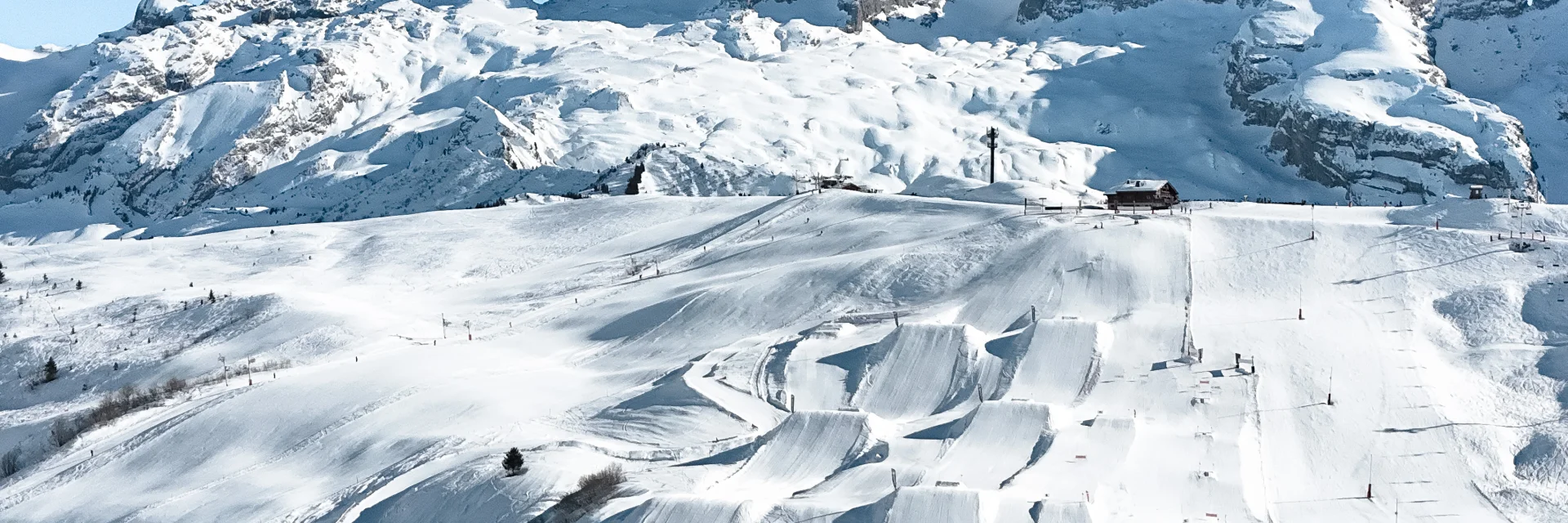 Une vue aérienne du snowpark du grand bornand et ses 6 hectares d'infrastructures freestyle avec la pointe percéeen arrière plan