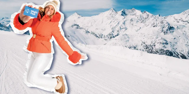 Une femme souriante, vêtue d’une veste orange et d’un pantalon blanc, saute de joie en tenant un Magic Pass, avec un panorama de montagnes enneigées en arrière-plan.