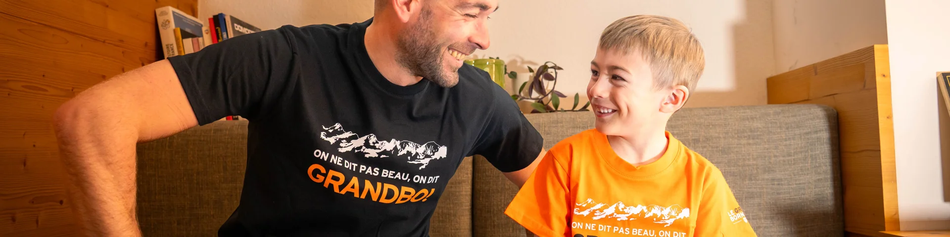 Un homme avec un petit garçon qui portent tous les 2 un tee-shirt en vente à la boutique de l'Office de tourisme