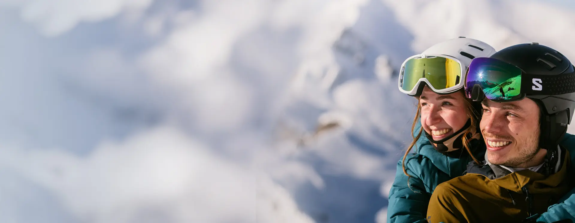 Un couple tout sourire heureux de se retrouver au ski.