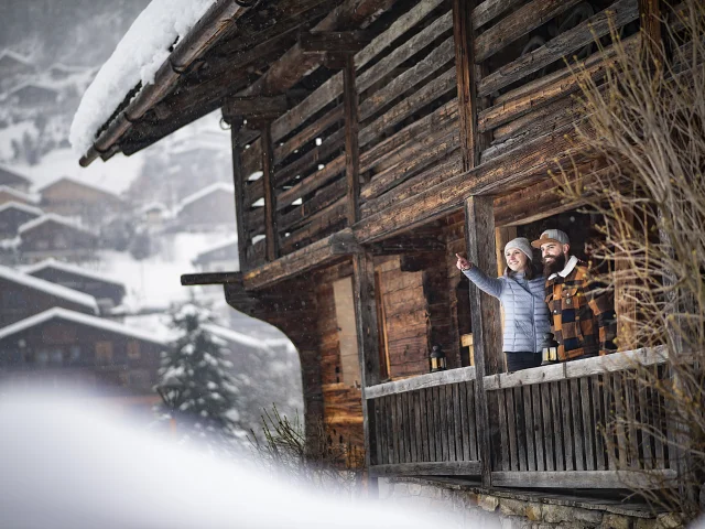 Jeune couple entrain d'admirer le paysage hivernal depuis le balcon de la Maison du patrimoine