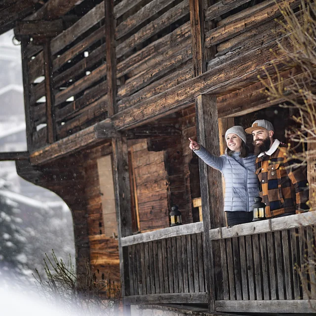 Jeune couple entrain d'admirer le paysage hivernal depuis le balcon de la Maison du patrimoine