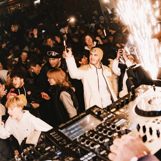 Groupe de personnes dansant devant un dj à l'occasion du Nouvel An