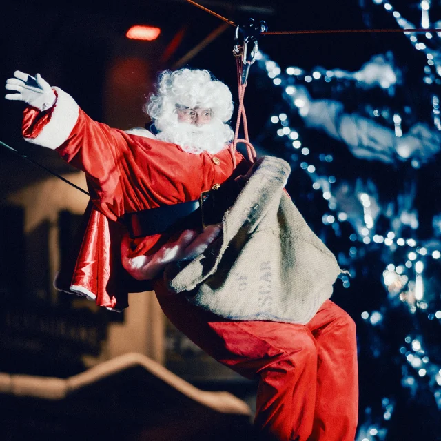Le père Noël descend du toit pour accueillir les enfants à l'occasion du Réveillon de Noël