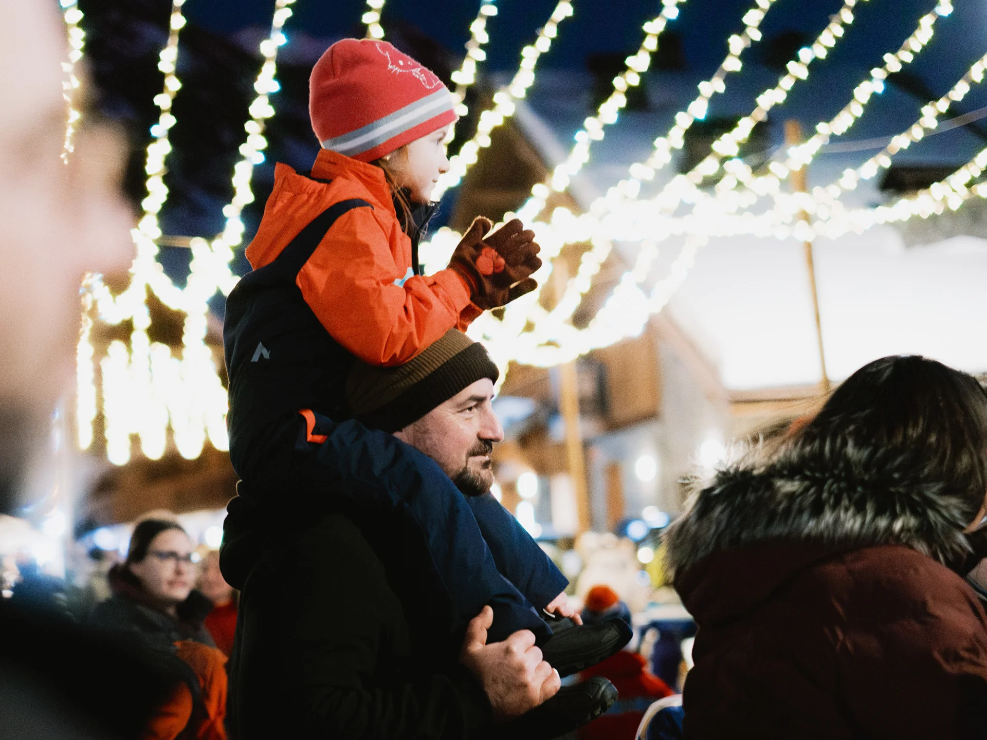 Un père porte son enfant sur ces épaules à l'occasion des animations faites durant les fêtes de Noël.