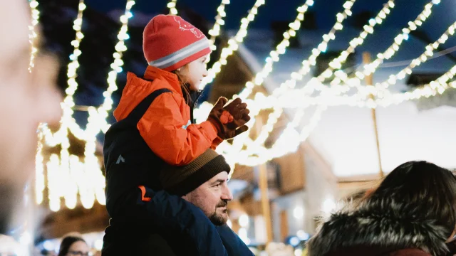 Un père porte son enfant sur ces épaules à l'occasion des animations faites durant les fêtes de Noël.