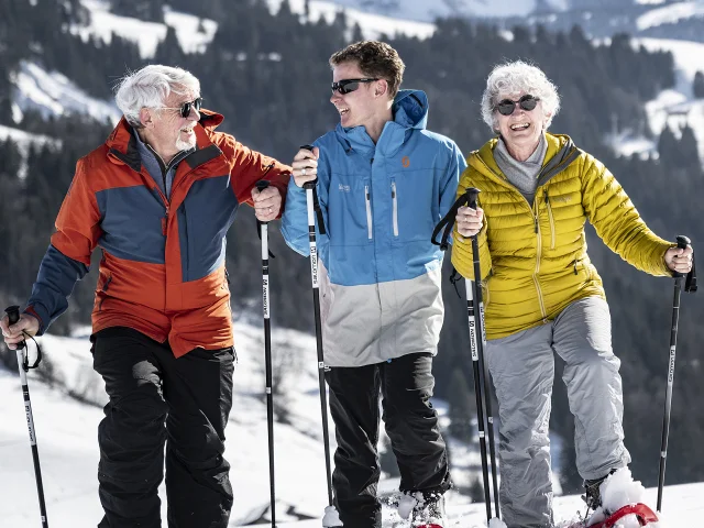 Des grands-parents et leur petit fils profitent d'une sortie raquettes