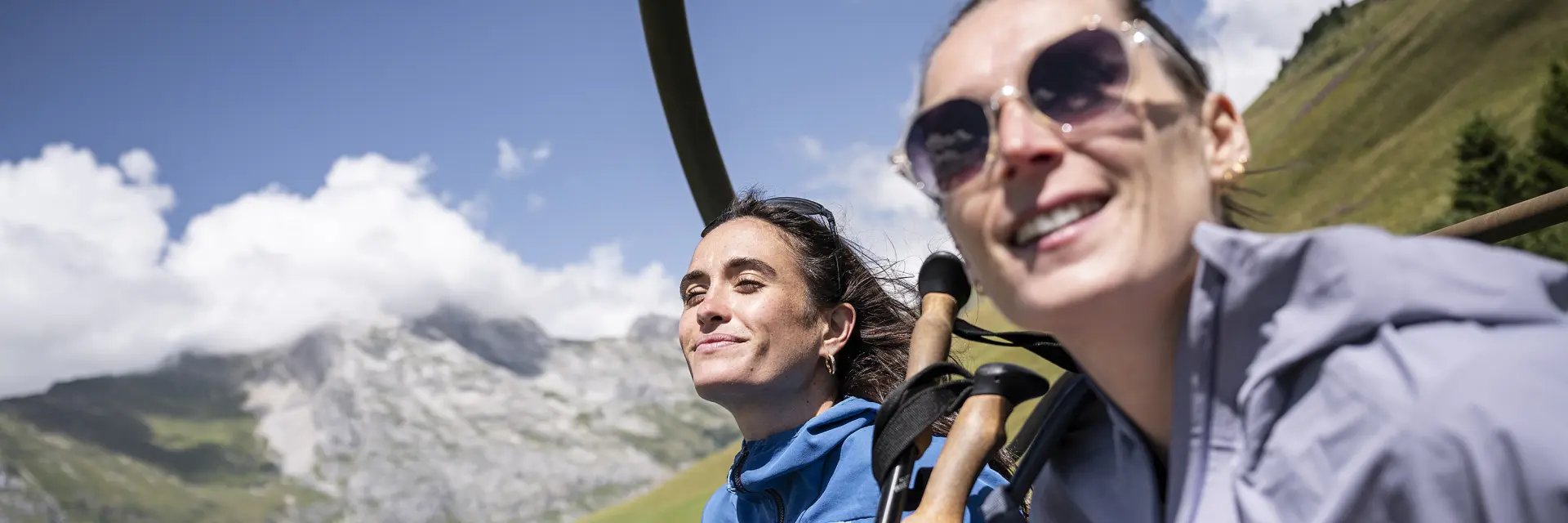 Deux amis, en éclat de rire, prennent les remontées mécaniques en été pour arriver en haut du mont Lachat