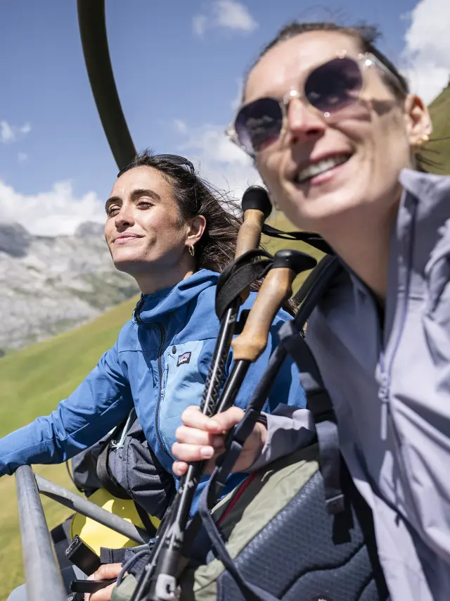 Deux amis, en éclat de rire, prennent les remontées mécaniques en été pour arriver en haut du mont Lachat
