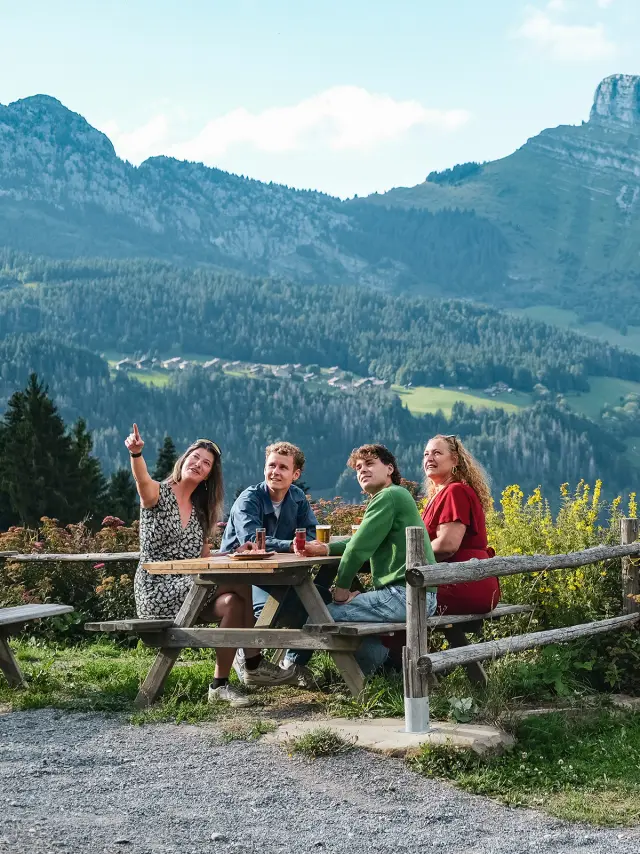 Moment de convivialité au restaurant les Frasses Jacquiers entre 4 personnes (2 femmes et 2 hommes, dont un jouant de la guitare). En toile de fond, le mont Bargy)