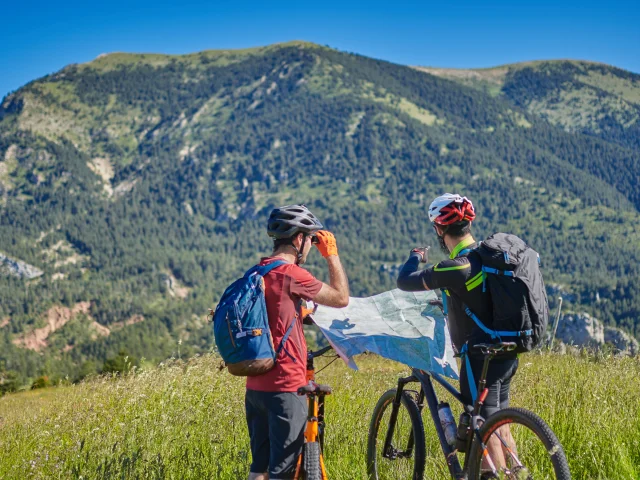 two men on mountain bikes with a map deciding where they are going
