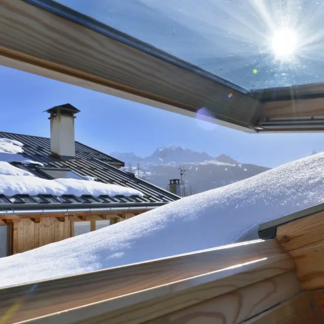 vista da una finestra aperta su un tetto coperto di neve in un cottage alpino