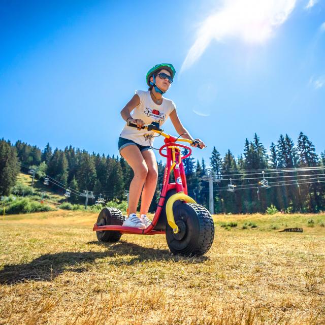Trottinette sur herbe en été aux 7 Laux à Prapoutel