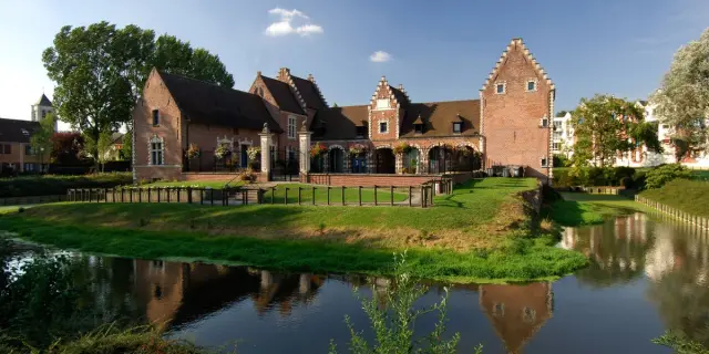 Château de Flers à Villeneuve-d’Ascq, bâtiment en briques rouges bordé de douves et de pelouses verdoyantes.