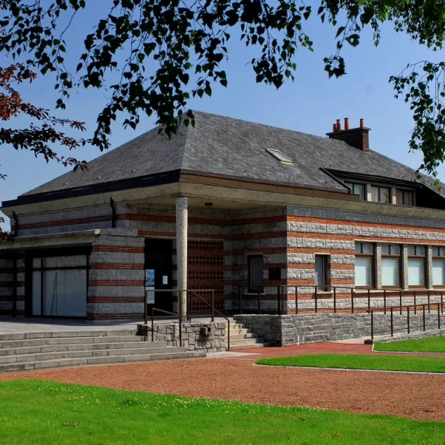 Vue latérale du Mémorial Ascq 1944 à Villeneuve-d’Ascq, entouré de pelouses et d’allées.