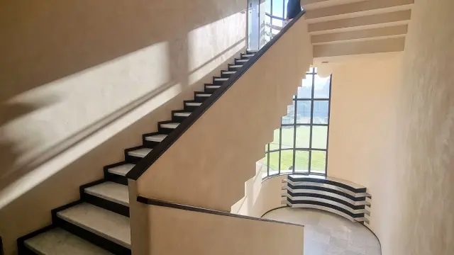 Escalier intérieur en marbre blanc aux lignes géométriques, baigné de lumière naturelle à la Villa Cavrois.