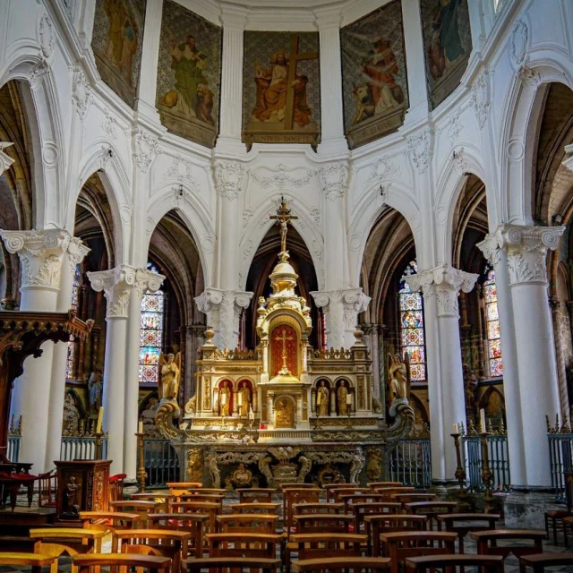 Chœur de la collégiale Saint-Piat à Seclin, avec autel orné, colonnes blanches sculptées et vitraux colorés.