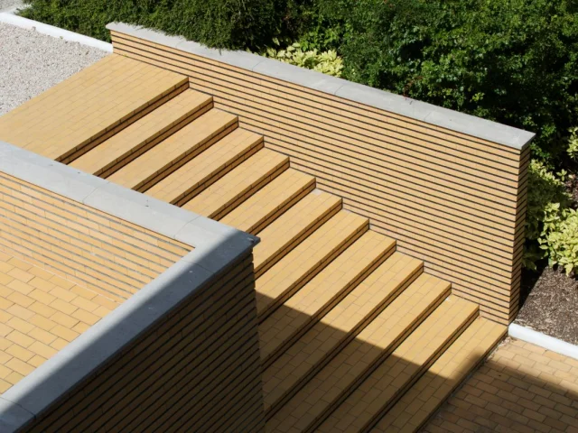 Escalier extérieur en briques jaunes de la Villa Cavrois à Croix, aux lignes géométriques sobres et intégrées au jardin.