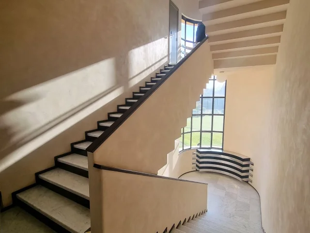 Escalier intérieur en marbre blanc aux lignes géométriques, baigné de lumière naturelle à la Villa Cavrois.