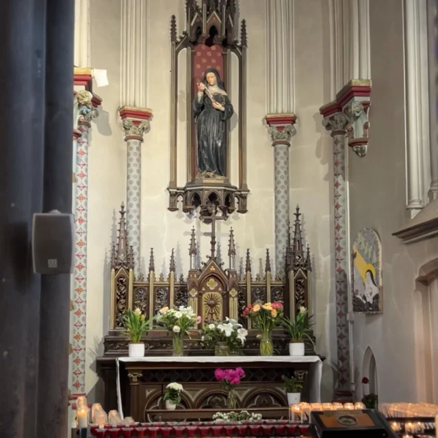 Autel orné de fleurs et de motifs néogothiques, avec statue de sainte Rita au sanctuaire de Vendeville.