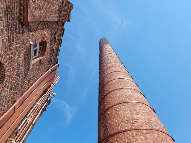 Cheminée en briques rouges photographiée en contre-plongée, symbole du passé industriel de Roubaix.
