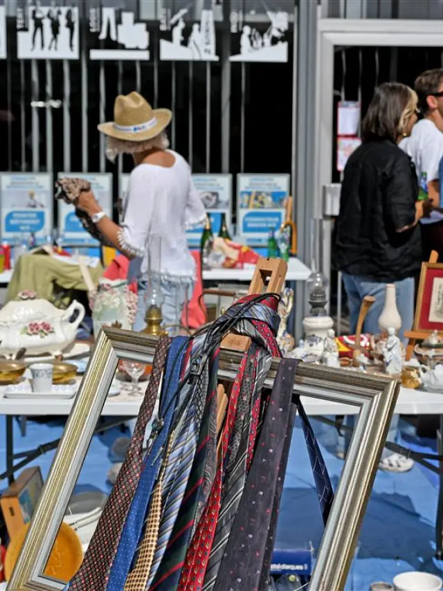 Stand at the Braderie de Lille with ties hanging in a frame, old crockery and a friendly atmosphere for bargain hunters.