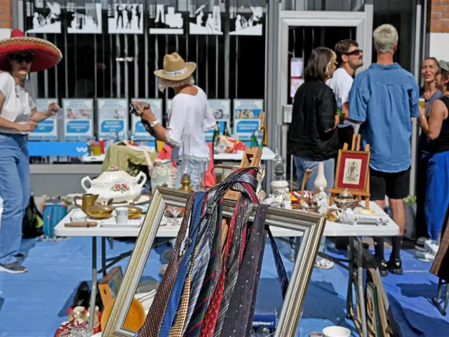 Stand at the Braderie de Lille with ties hanging in a frame, old crockery and a friendly atmosphere for bargain hunters.