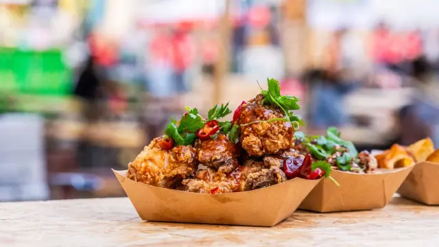Portion of fried chicken garnished with coriander and chilli peppers, served at the Lille Street Food Festival.