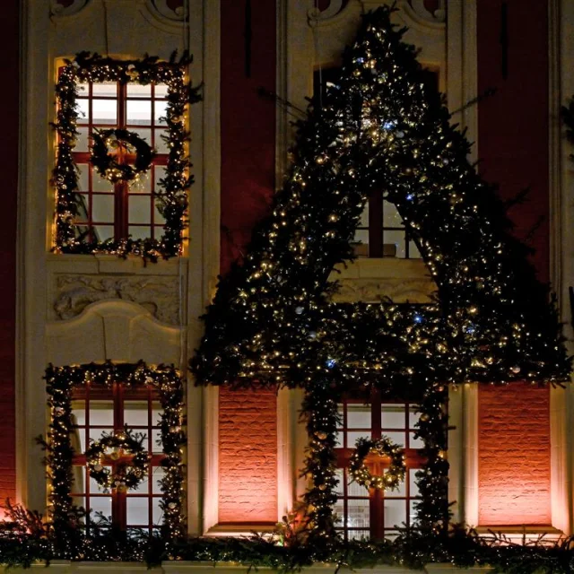 Façade ornée de guirlandes et couronnes lumineuses à Lille pendant les fêtes.