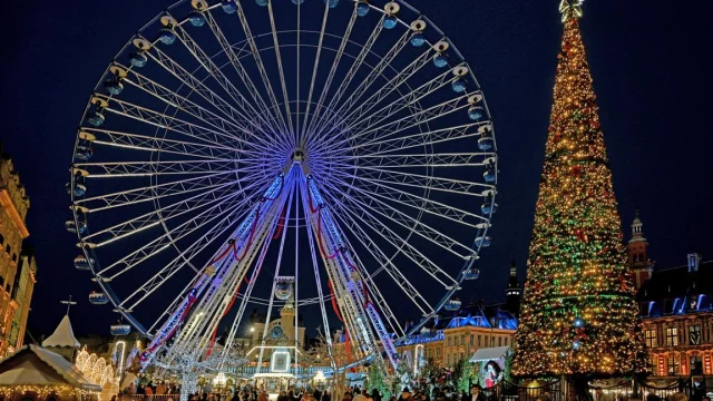 Vue festive de la grande roue et du sapin géant sur la Grand’Place de Lille de nuit.