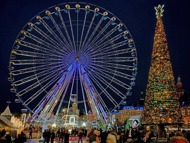 Vue festive de la grande roue et du sapin géant sur la Grand’Place de Lille de nuit.