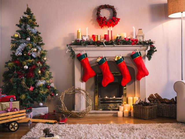 Christmas tree with presents near the fireplace at home in the living room