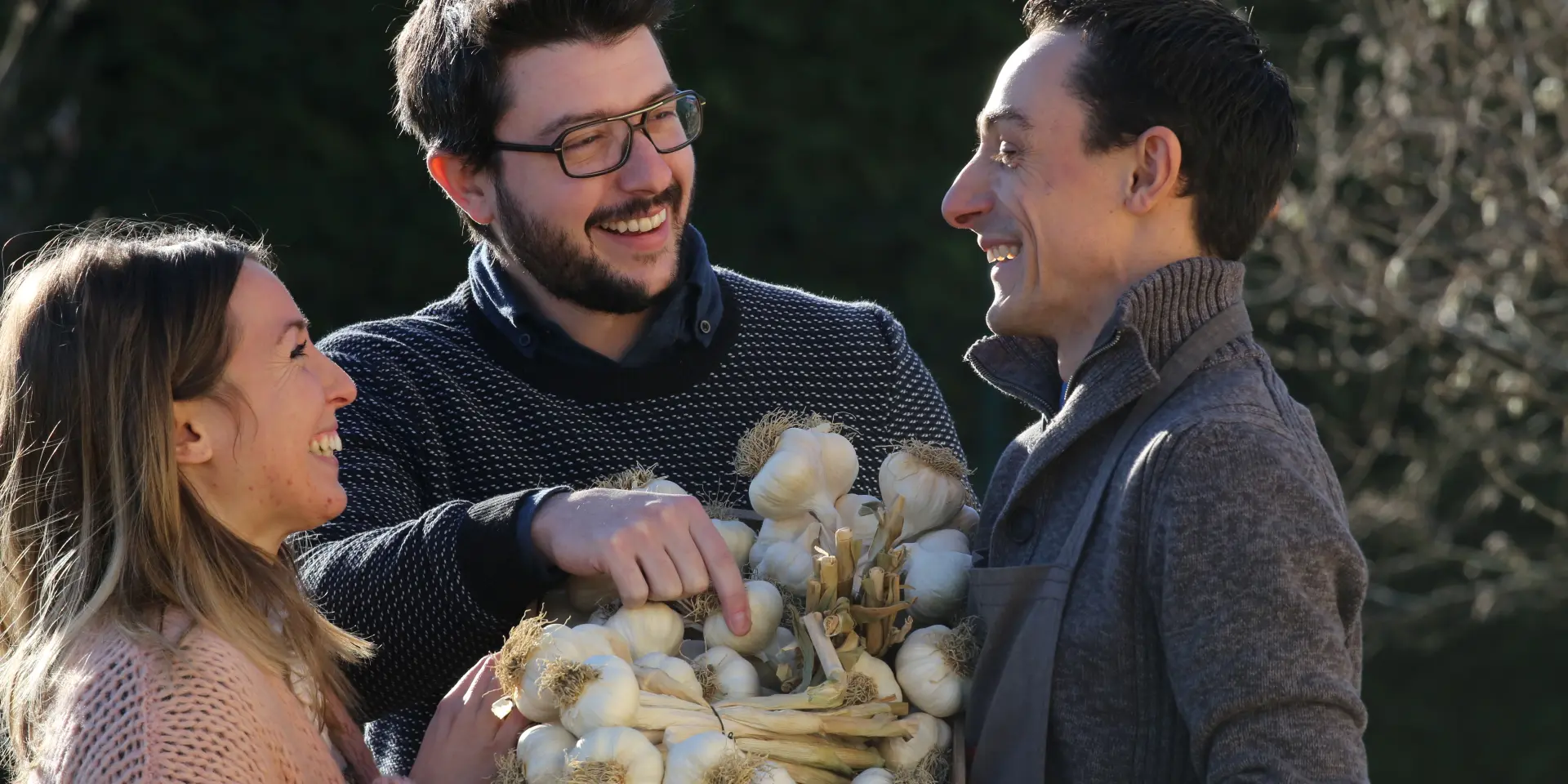 Couple discutant avec un producteur d’ail rose de Billom devant une caisse en bois.