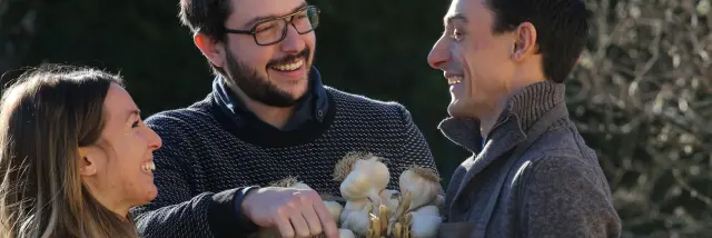 Couple discutant avec un producteur d’ail rose de Billom devant une caisse en bois.