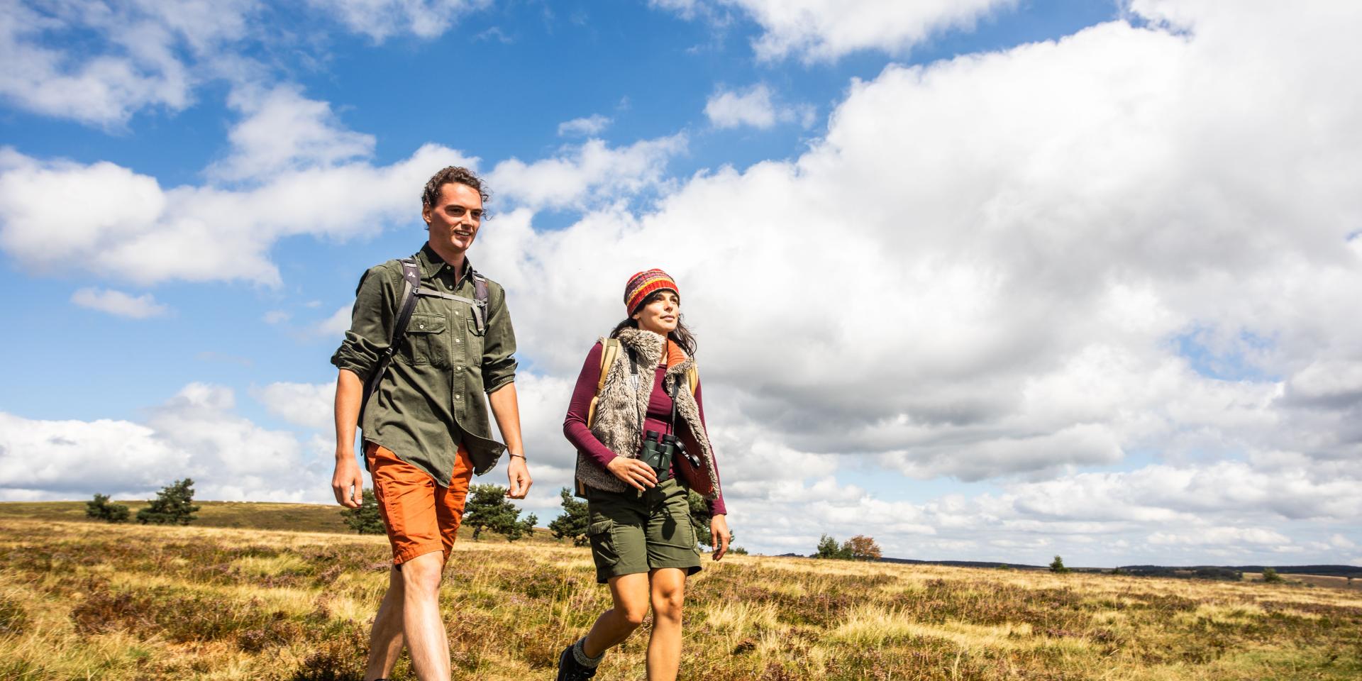 Couple en randonnée sur les Hautes Chaumes sous un ciel bleu.