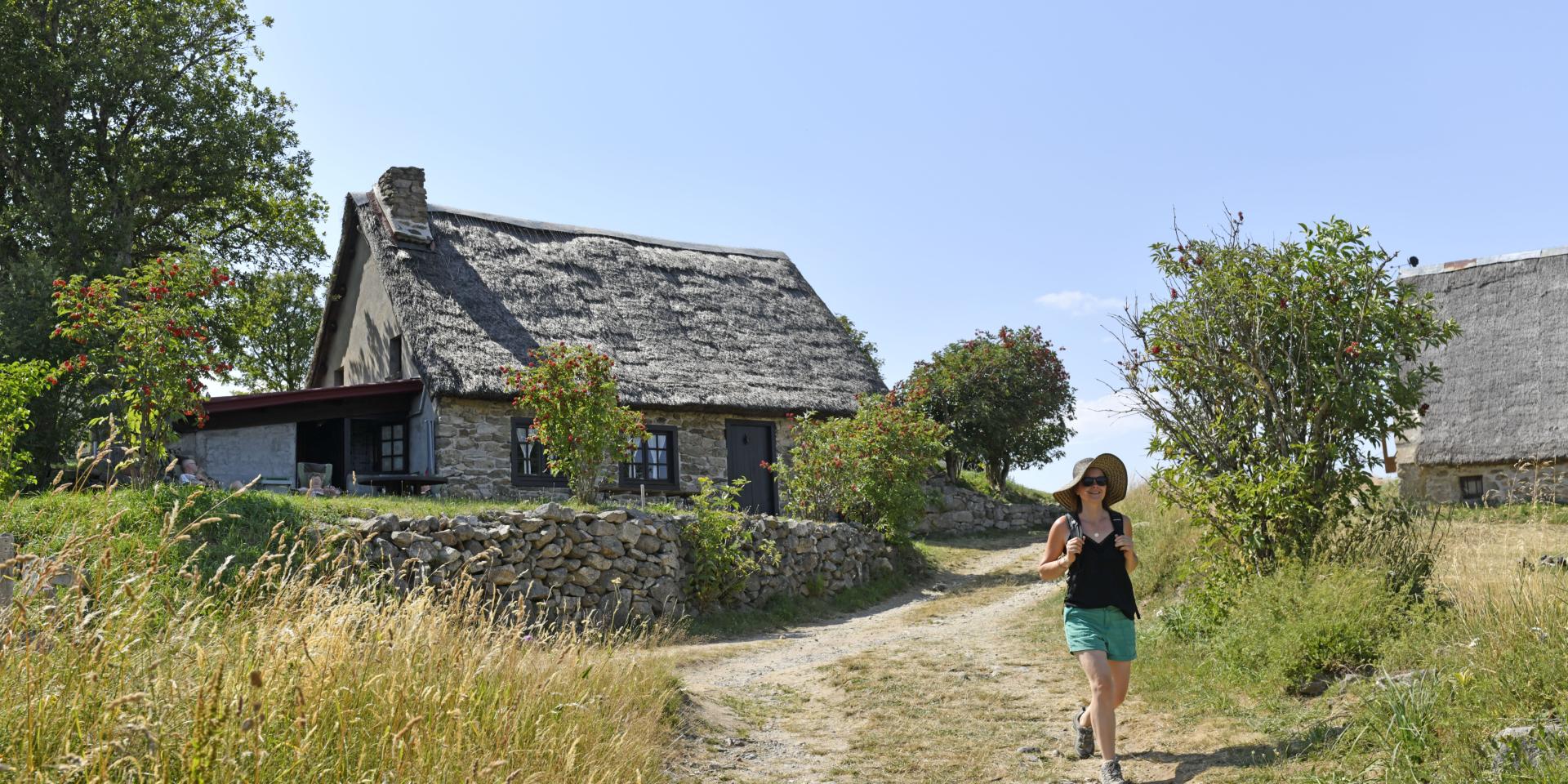 Randonnée estivale avec vue sur des jasseries et la nature environnante.