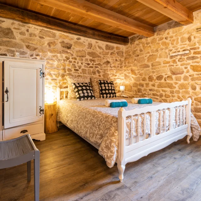 Chambre confortable et lumineuse dans le gîte de la Neira à Ravel, avec décoration rustique.