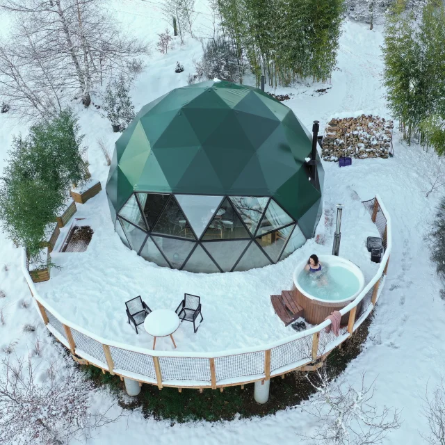 Vue aérienne de l’éco-lodge des Bois de Luna, entouré de neige, dans un paysage naturel et apaisant.