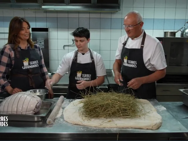 Carinne Teyssandier, un chef et un apprenti devant des ingrédients dans une cuisine, portant des tabliers, scène de l’émission culinaire Nos terres gourmandes sur France 3.