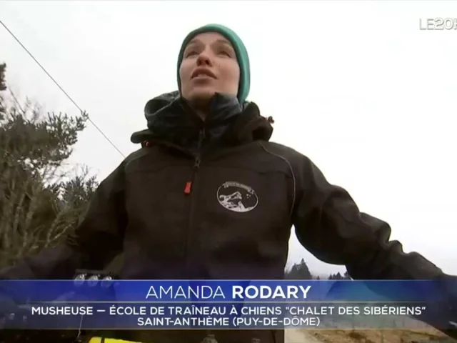 Amanda Rodary, musheuse, sur son traîneau à chiens, vêtue d’une veste et d’un bonnet, dans les montagnes de Saint-Anthème.